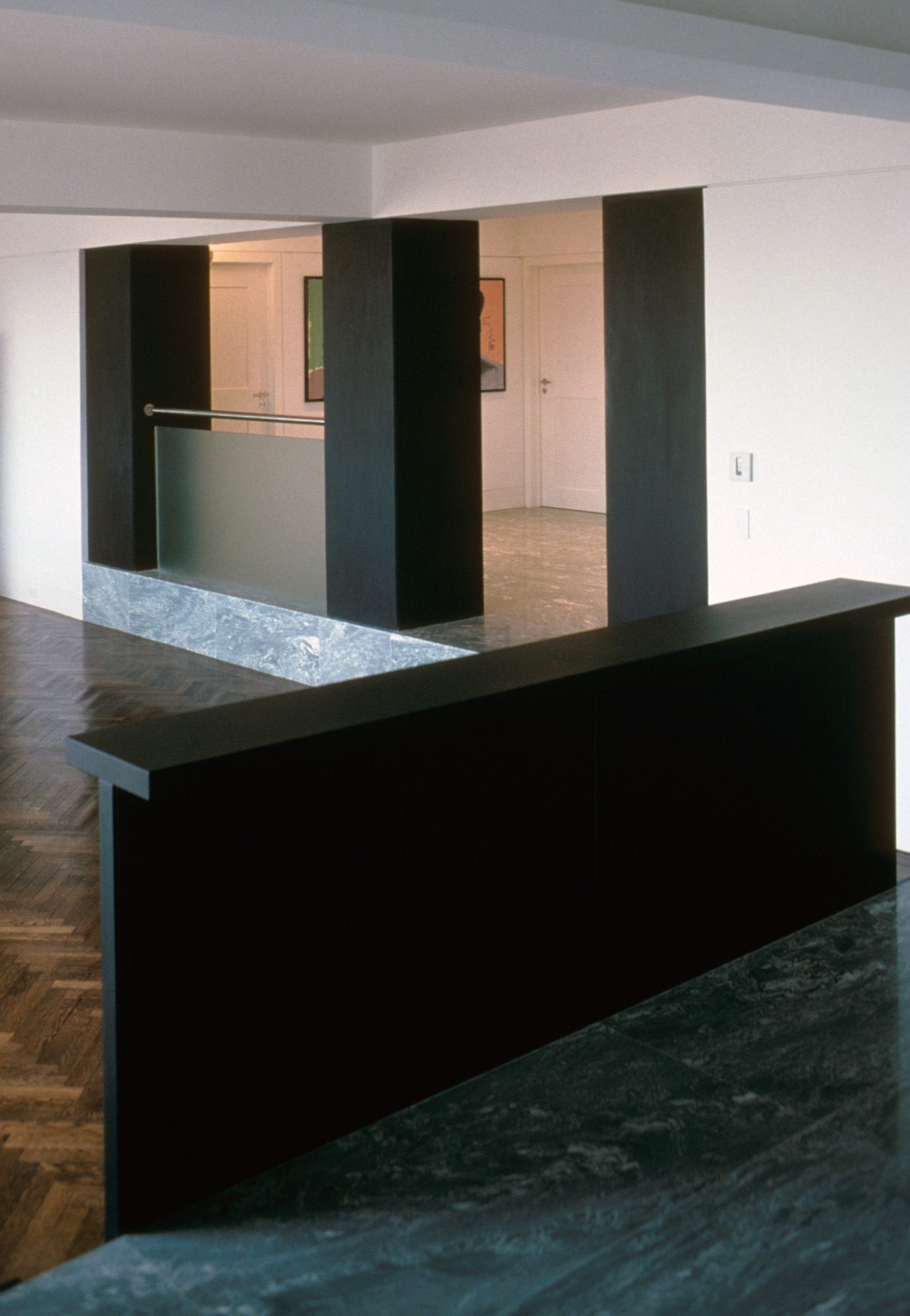 Open-plan kitchen with oak veneer cabinetry, waterfall quartz island, and floor-to-ceiling tree view
